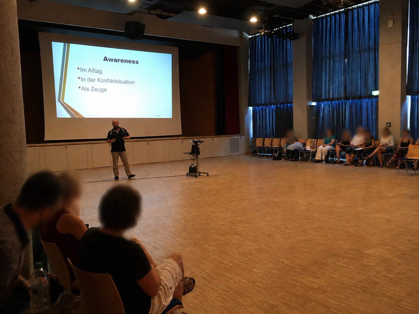 Vortrag zu Konfliktprävention und Selbstschutz vor einer großen Teilnehmergruppe